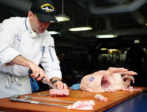 船のスタッフに豚の解体法を教える調理インストラクター