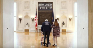 アナポリス海軍兵学校の記念講堂を歩む老人と付き添う若い女性